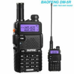 Two Baofeng DM-5R handheld radios with purple backlit screens and extendable antennas side by side, showcasing their compact design and keypad.",