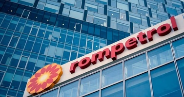 Innotech Rompetrol Sign on a Glass Office Building with a Yellow Sunflower Logo Beside It.